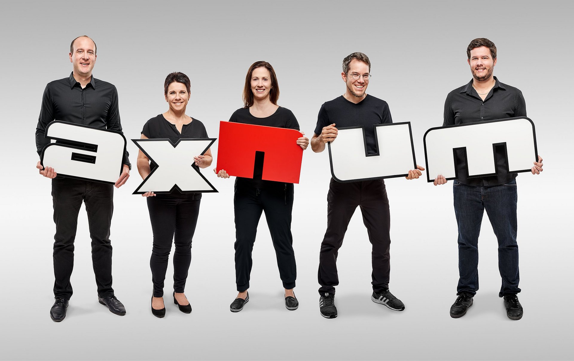 Axnum-Mitarbeiter mit Axnum-Buchstaben